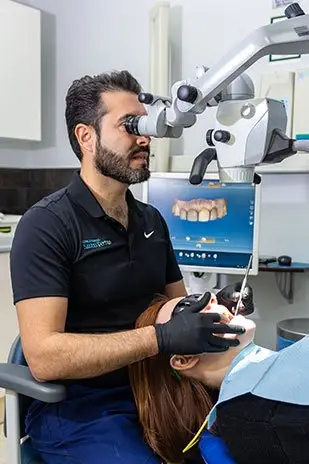 Odontólogo trabajando con microscopio dental